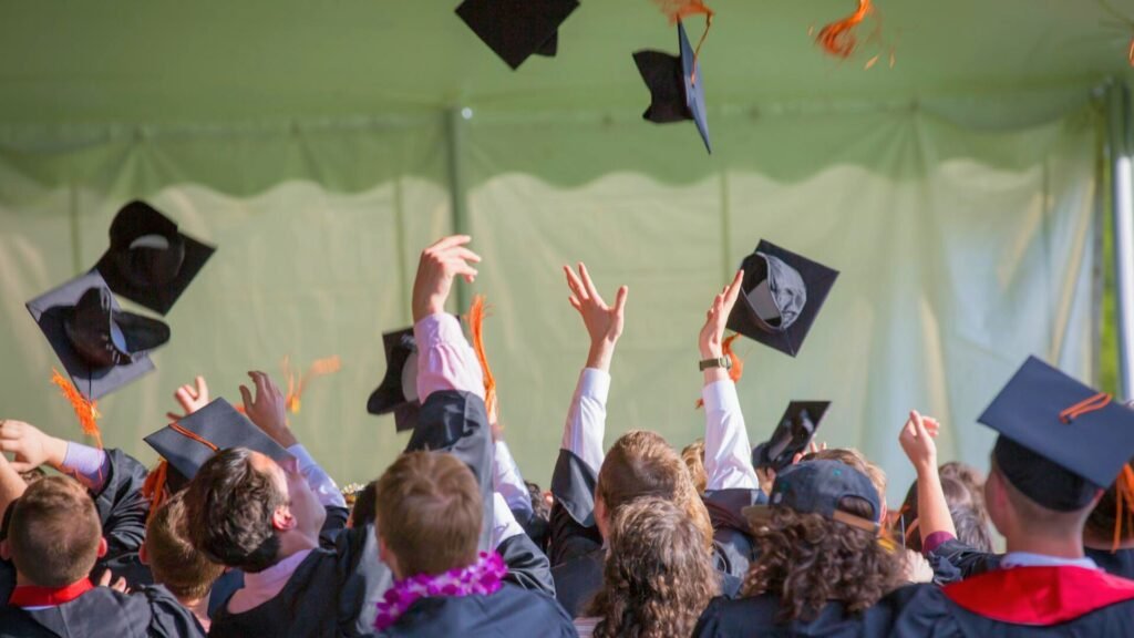 Graduates celebrating by tossing caps at commencement, symbolizing Radford University’s $2.5M investment to combat the $1.77T U.S. student debt crisis and promote financial resilience